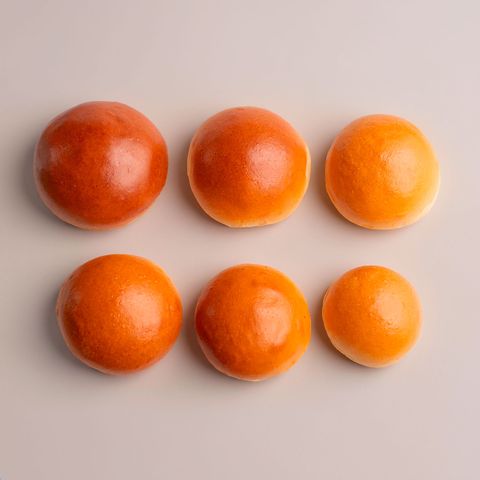 Six plain golden burger buns arranged in two even rows